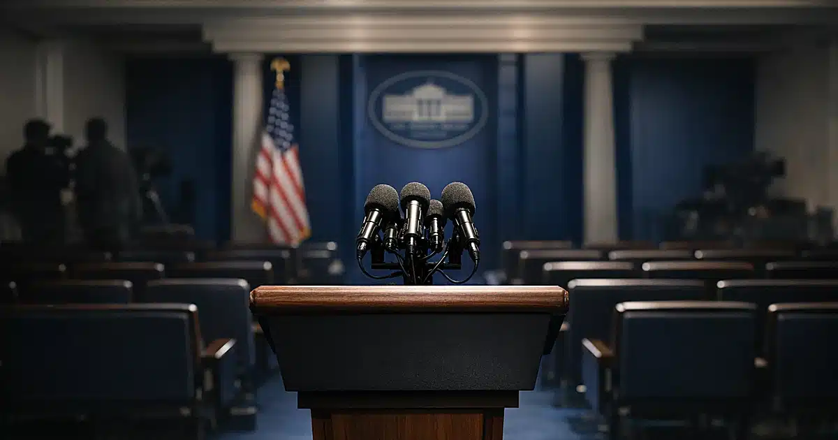 Empty White House press briefing podium with multiple microphones under dramatic overhead lighting