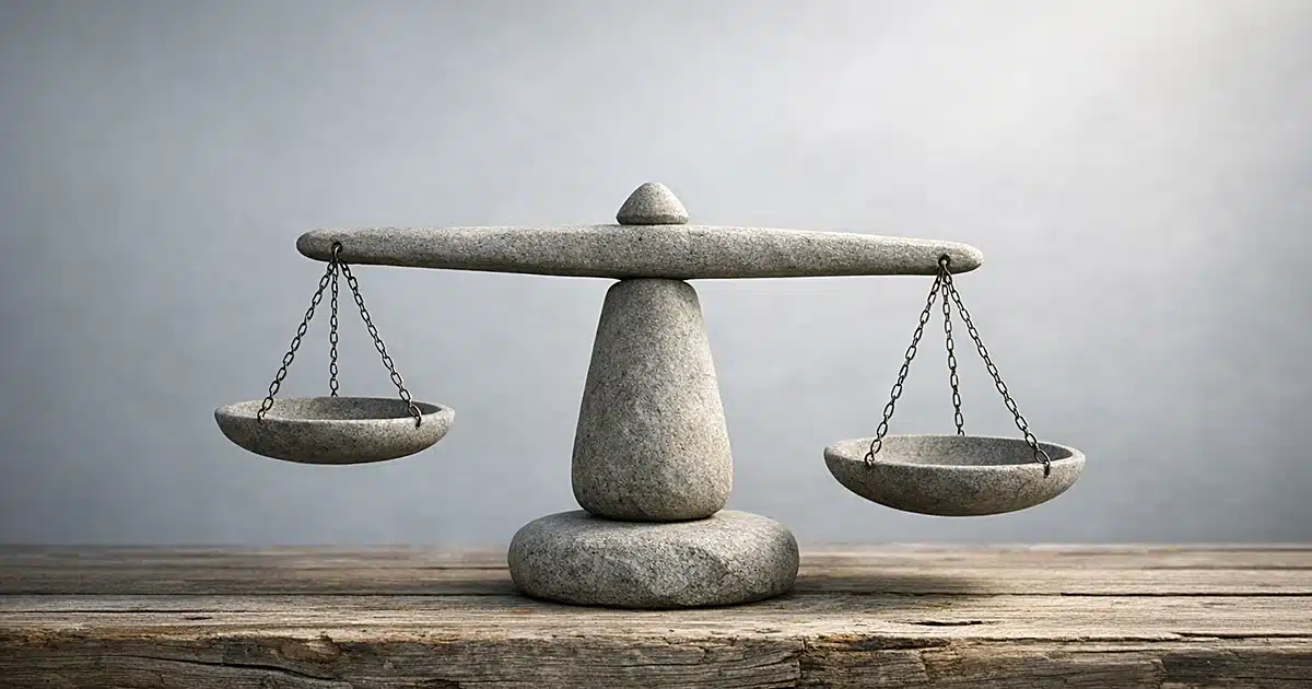 Abstract stone balance scale on wooden surface with soft lighting representing justice and accountability themes