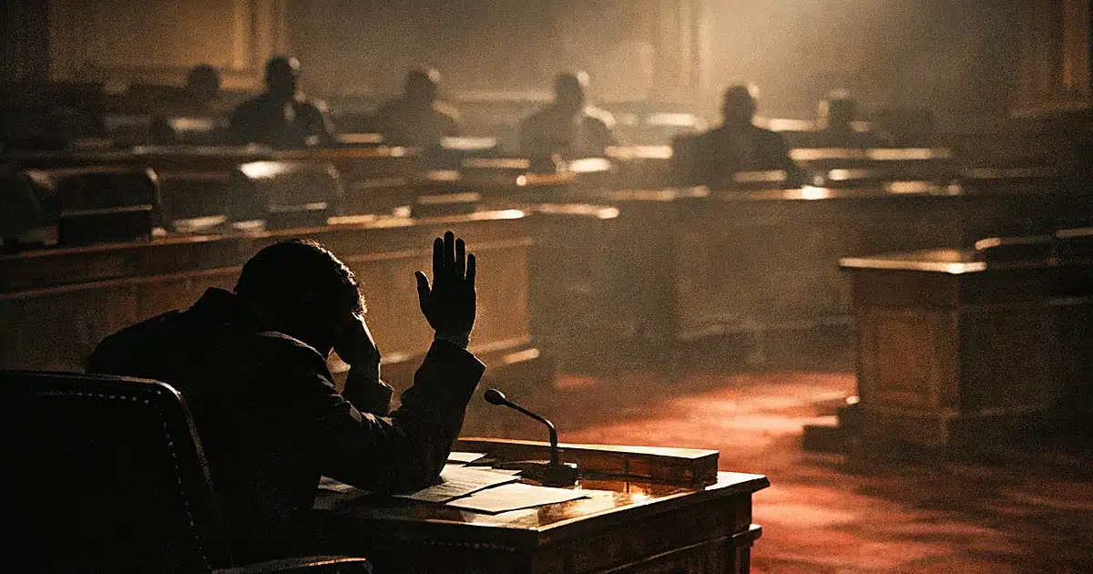 Silhouetted legislator voting alone in a dimly lit chamber with empty desks and distant figures in background