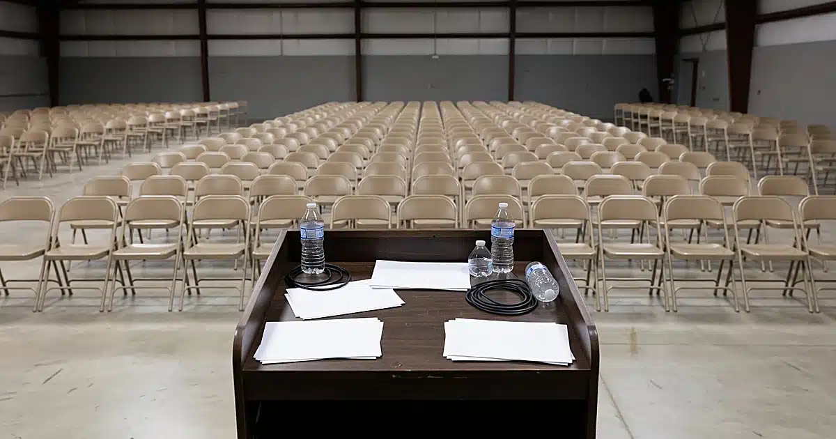 Empty political rally venue with podium and folding chairs awaiting campaign event