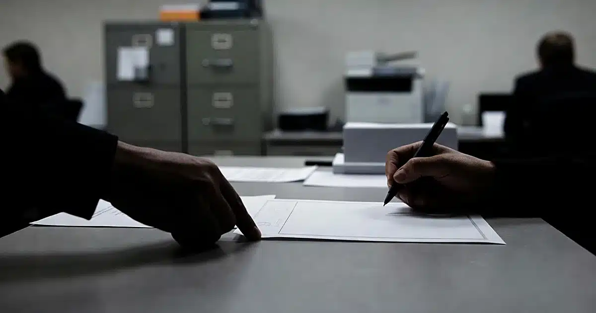 Silhouetted hands adjusting official document on government office desk with shallow depth of field