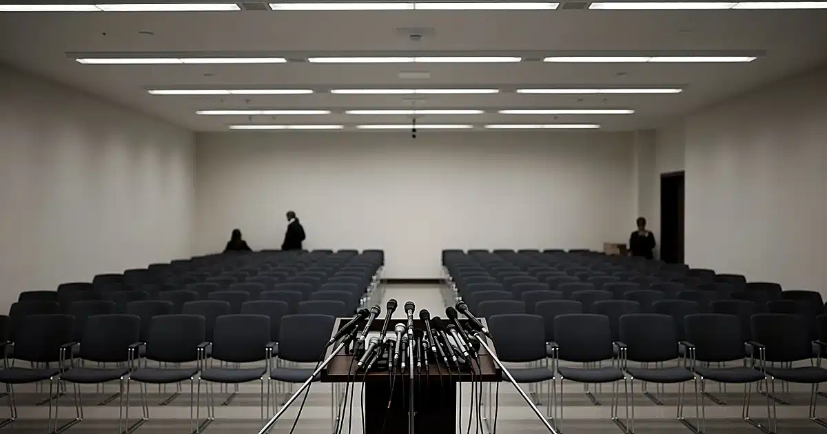 Empty White House press briefing room with vacant podium and microphones surrounded by press chairs